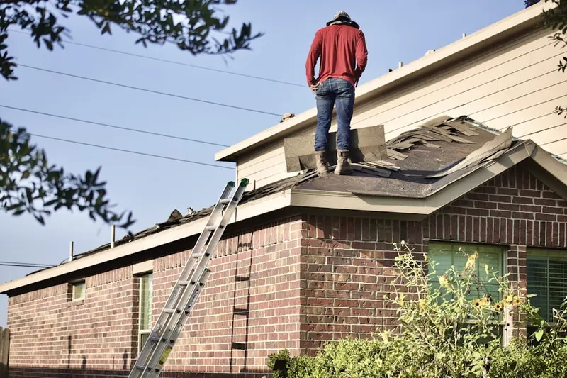 Professional roofer working on a residential roof in Iroquois Point